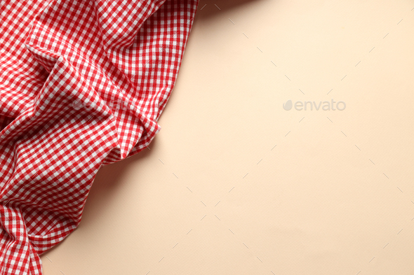 Red and white checkered tablecloth on beige background Stock Photo by