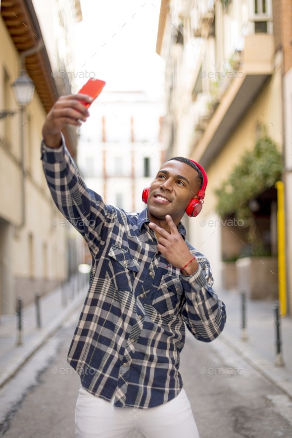 portrait african american man taking a photo with mobile phone - Stock Photo - Images