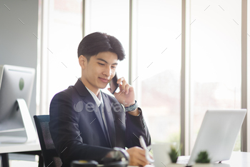 Business Asian man working using smart phone with smiling and confident emotion.