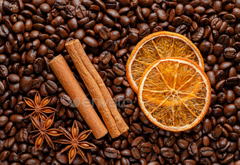 Spices on roasted coffee beans background. Top view, flat lay.