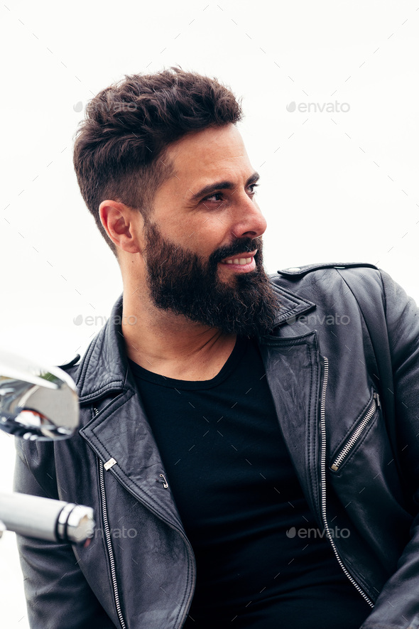 man in leather jacket leaning on his motorcycle Stock Photo by Raul_Mellado