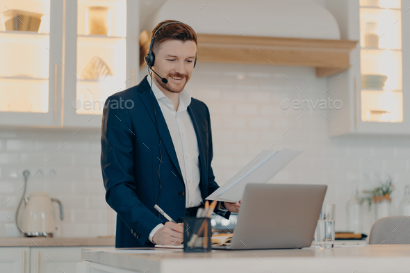 Happy executive manager holding document with report while working remotely - Stock Photo - Images