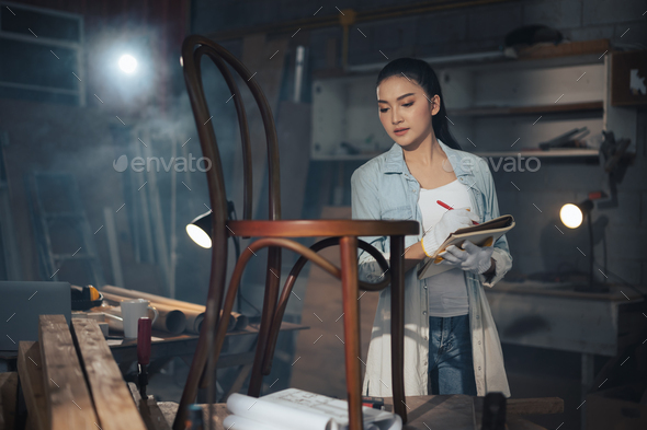 Young Asian designer furniture woman Carpenter uses a tape measure