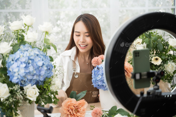 Asian woman in home make an online presenting and live broadcast for sale her flowers