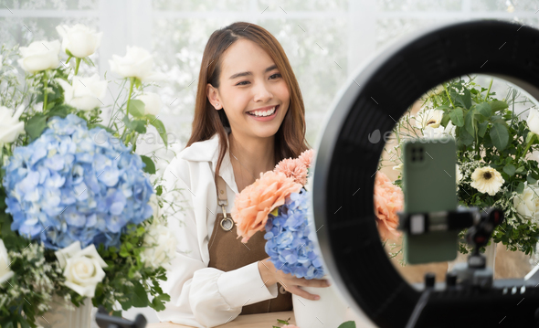Asian woman in home make an online presenting and live broadcast for sale her flowers