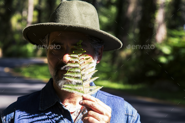 Earth day and love for nature concept with attractive man with a fern leaf covering one eye - Stock Photo - Images