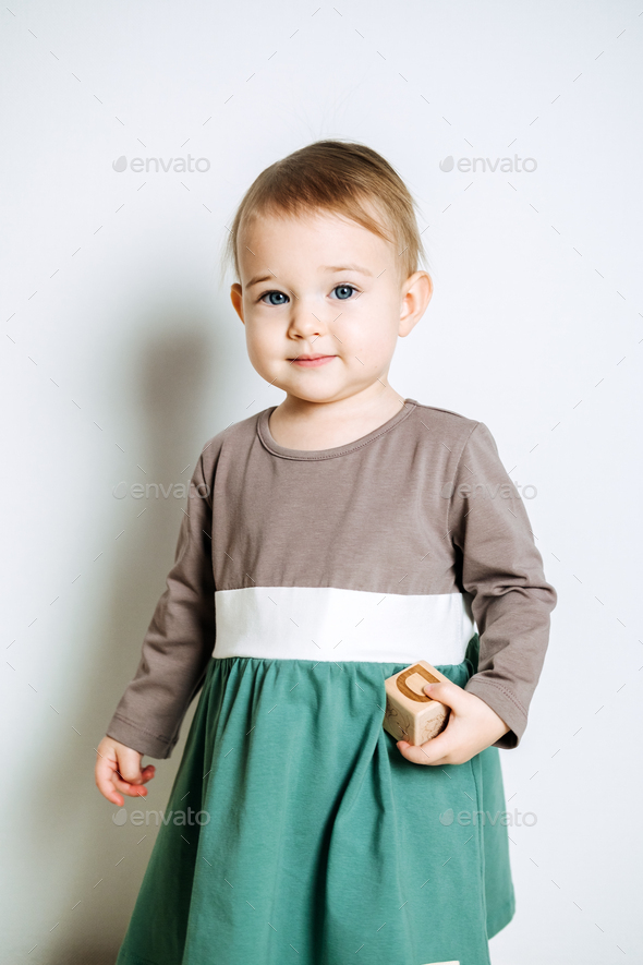 Baby fashion. Unisex color clothes for babies. Cute baby girls in neutral color palette cotton dress