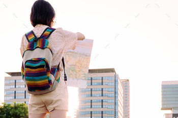 rear view of a woman with backpack looking a map