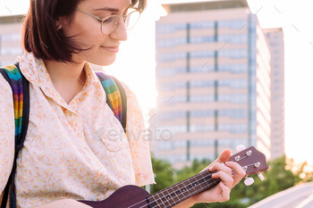 portrait of beautiful young woman playing ukulele