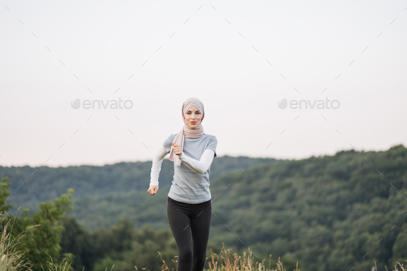 Pretty fitness woman, jogging in the green park Stock Photo by