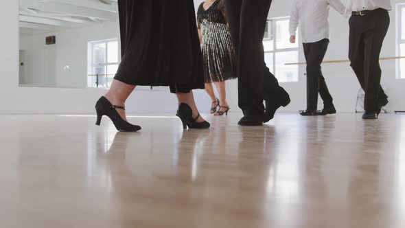 mixed race male dance teacher taking a ballroom dancing class at a dance studio alt