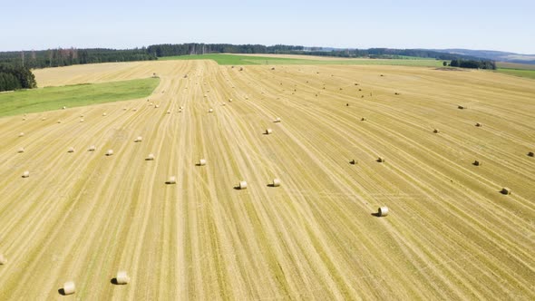 Aerial Drone Shot  a Field with Hay Bales in a Rural Area on a Sunny Day alt