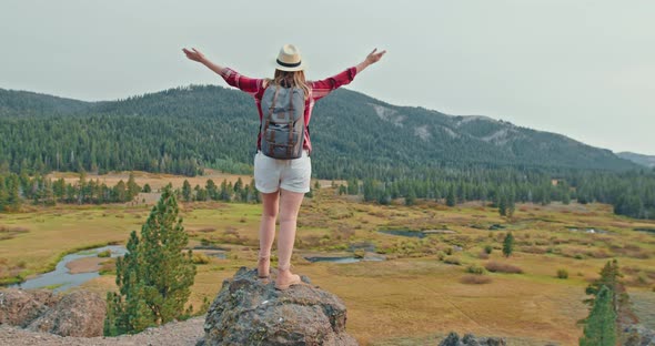 Young Woman in Red Classic Shirt Standing on Top of Mountain on Early Autumn Day alt