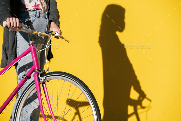 unrecognizable woman on a bicycle wearing mask