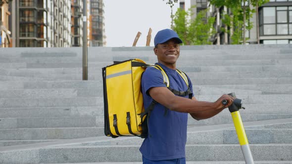 Portrait Smiling Afroamerican Man Courier with Backpack and Electric Scooter alt