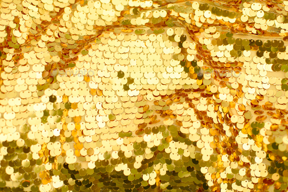 Background from golden scales sequin. abstract glittery