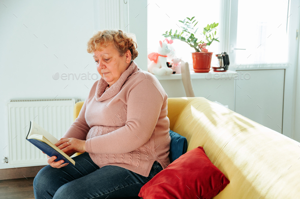 Adult mature fat lady enjoying hobby spending free leisure time with funny modern novel literature