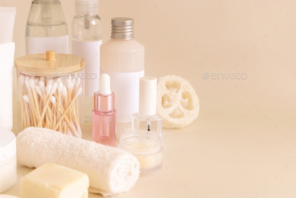 Natural cosmetic jarsand bottles and skin care accesories on light yellow close up