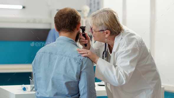 Female otolaryngologist consulting patient in medical cabinet