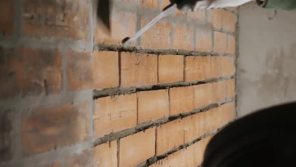 The Builder Applies Cement Mortar To the Brick Wall.