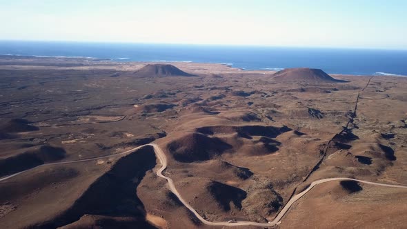 Aerial View of a Road Leading Through Vast Area of Volcanic Land and Mountains