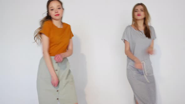Two carefree young girls going crazy. Women in hipster summer clothes in studio alt