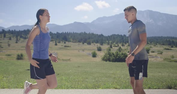 Couple of Determined Athletes Stretching Together Warming Up and Preparing for Running Training on a