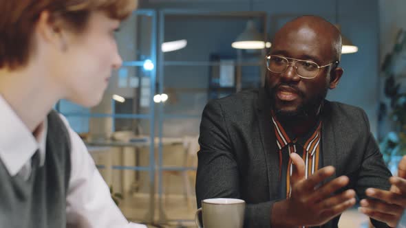 African American Businessman Talking with Colleague at Night Meeting alt