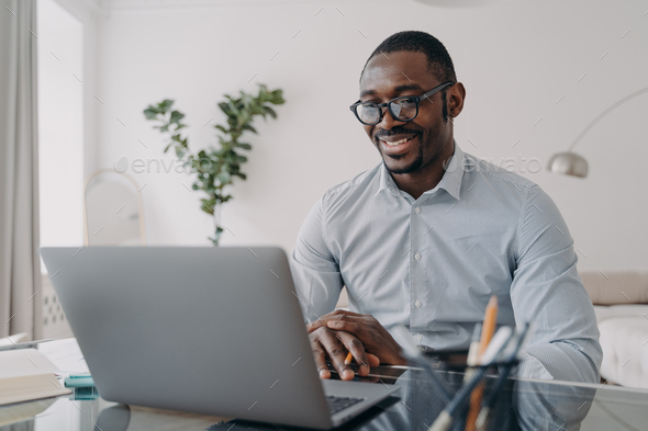 Online freelance remote job. African american man is speaking in front of camera of pc.
