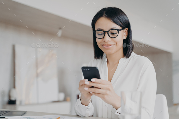 Happy female hold phone chat in social network read good news, shopping via  online store app at home Stock Photo by StudioVK