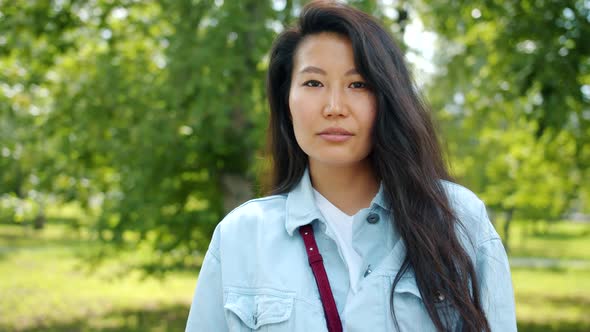 Portrait of Happy Asian Woman Smiling Laughing Standing Outdoors in Autumn Park alt