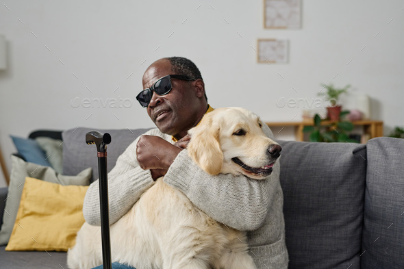 Blind man sitting with guide dog