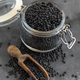 Glass jar of dry black lentils beans with a scoop on grey table close up,  healthy protein diet - PhotoDune Item for Sale
