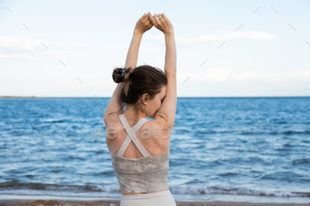 Relaxed woman breathing fresh air and stretching arms on beach, freedom concept