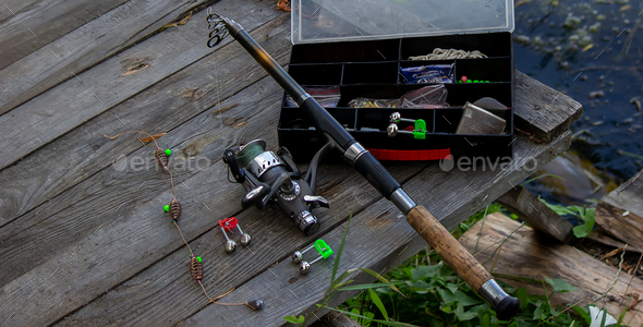 Fishing tackle on the river bank, bait rod, spinning rod, fish. Selective  focus Stock Photo by solovei23