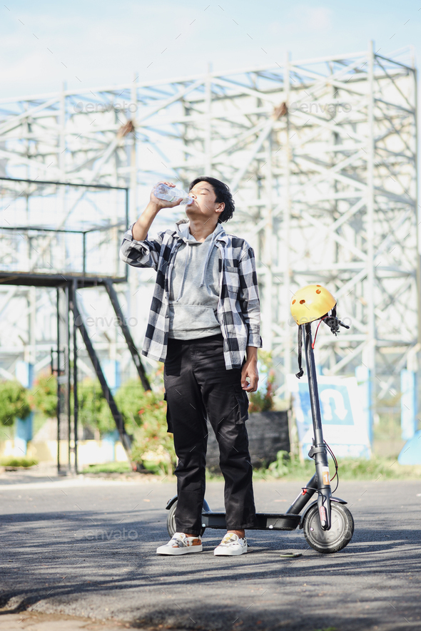 Electric scooter rider drinking