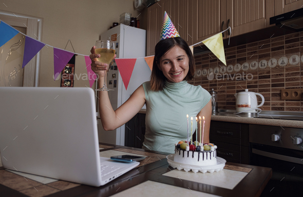 Woman blowing out the candle on the birthday cake and making video call.