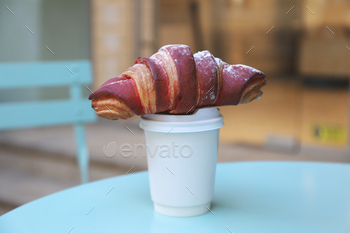 Concept of tasty breakfast with cup of coffee and croissant