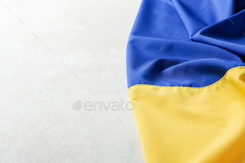 Ukrainian flag on light textured background, space for text