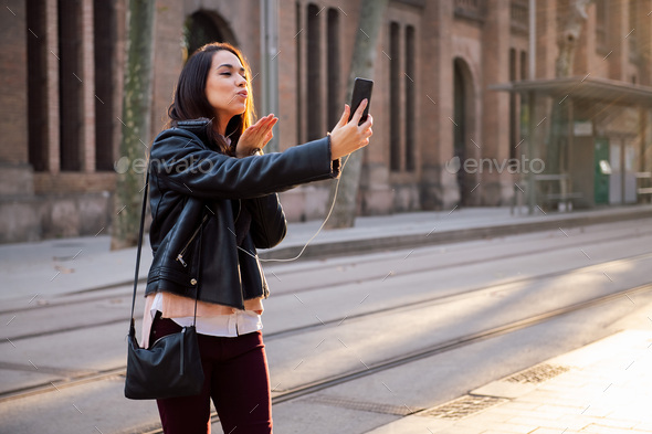 young woman sending a kiss by making a video call