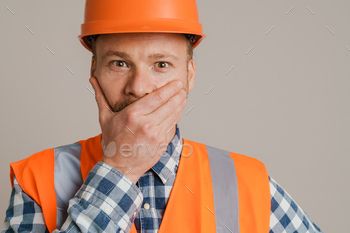 White man worker wearing helmet and vest expressing surprise