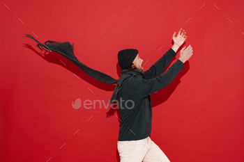 White man in warm clothes screaming with hands up