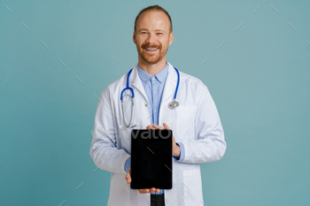 White male doctor wearing lab coat showing tablet computer