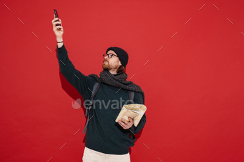 Ginger puzzlement man wearing hat and scarf using mobile phone