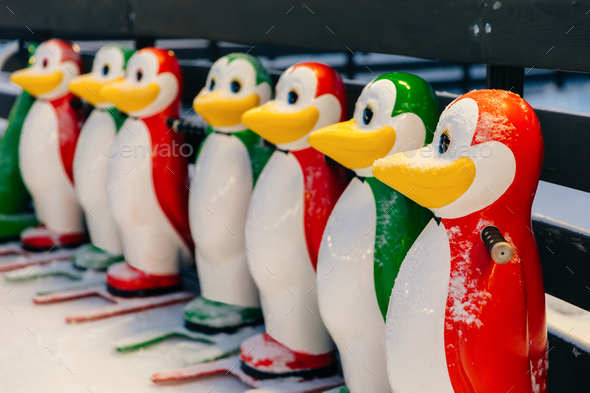 colorful skate aids in shape of funny penguins, needed to keep balance on ice rink