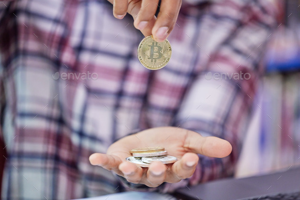 How much is it worth to you. Shot of an unrecognisable man holding bitcoins.