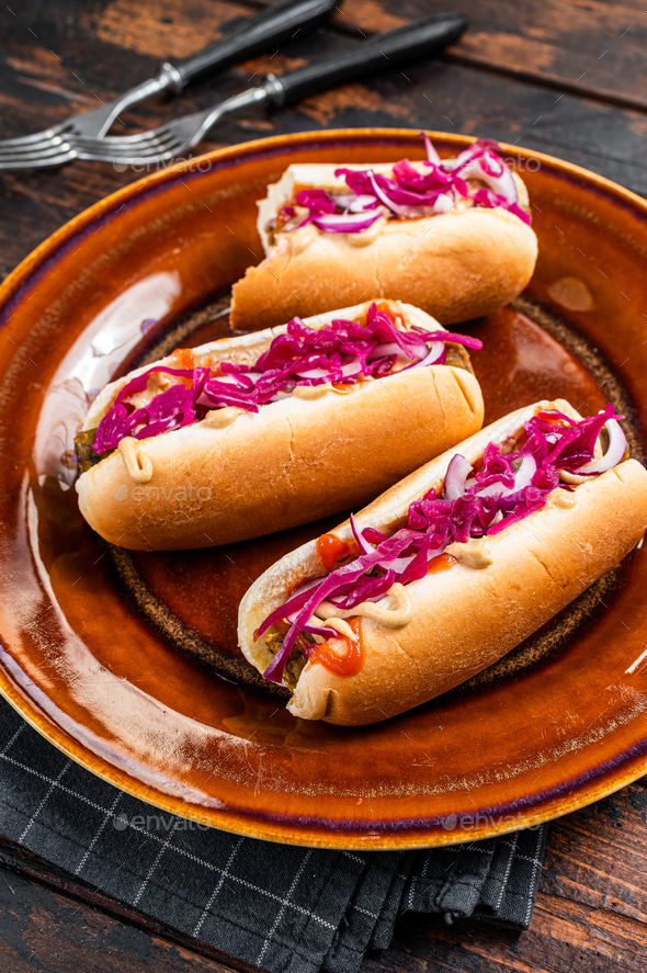 Street food Vegan hotdogs with cabbage and meatless sausage. Dark