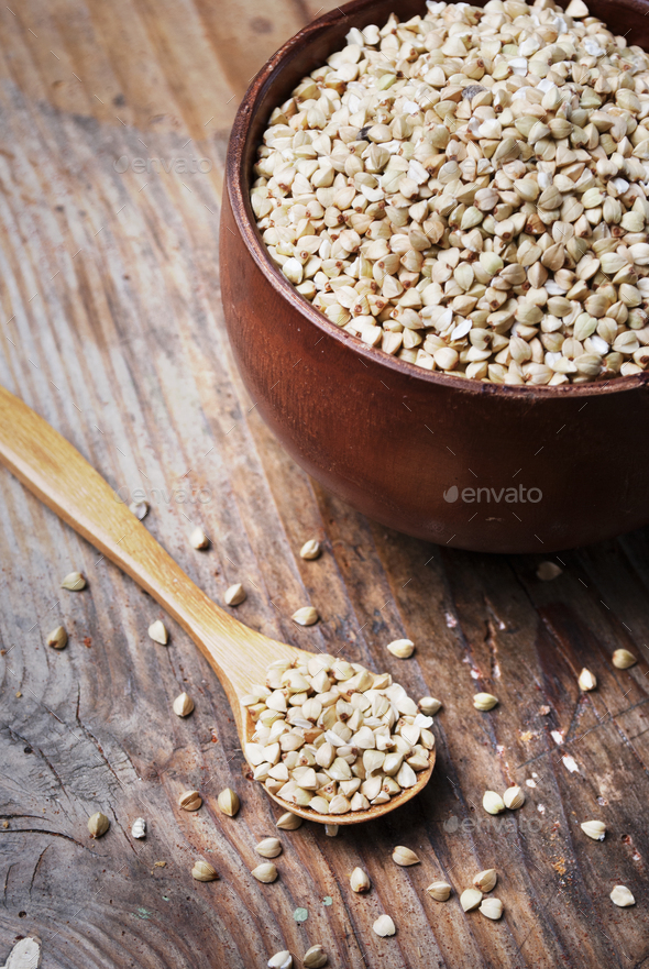 Buckwheat grain heap in wooden bowl - Stock Photo - Images