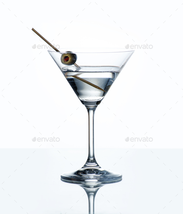 Dry martini with green olive in cocktail glass  - Stock Photo - Images