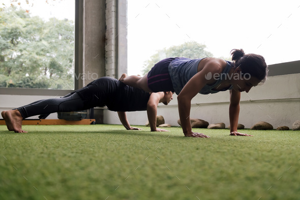 sportsman and sportswoman doing push-ups together